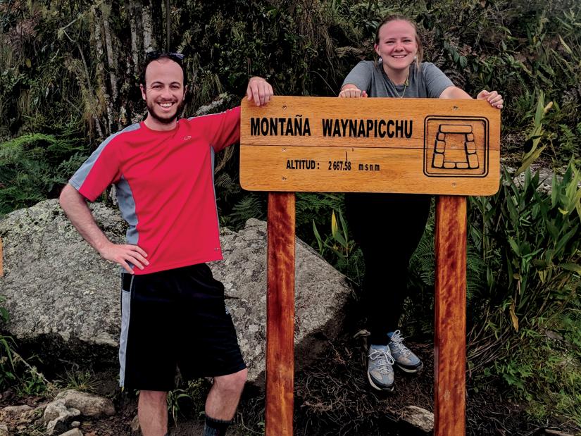 two students standing in font of a trail sign
